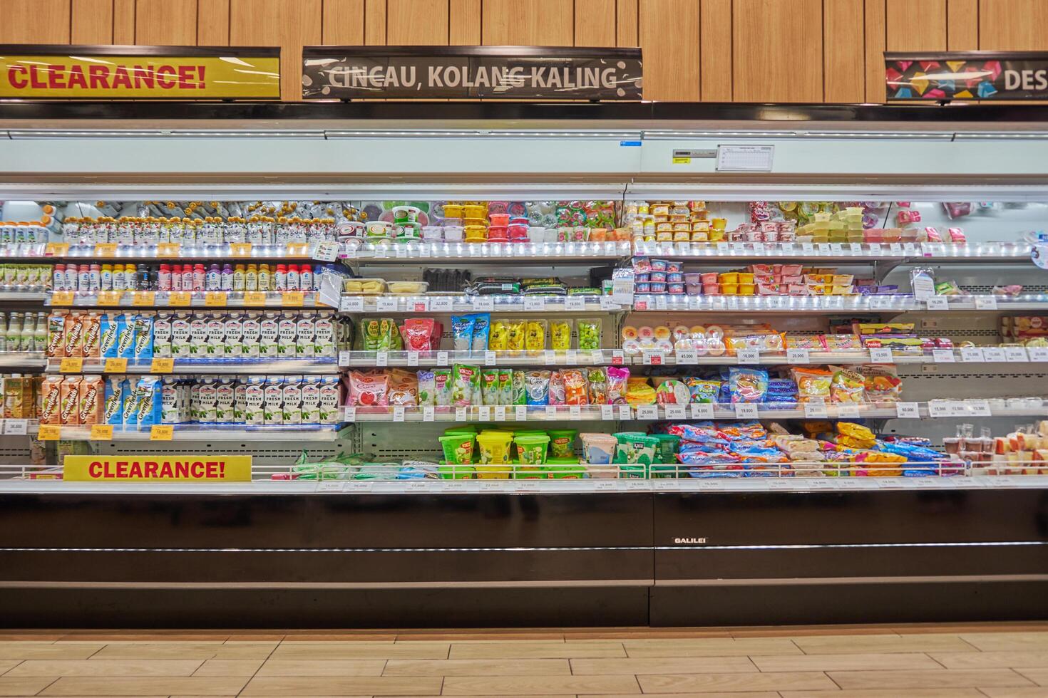 Display of various food and beverages on supermarket shelves with various price and discounts Bekasi, Indonesia - September 15, 2024 photo