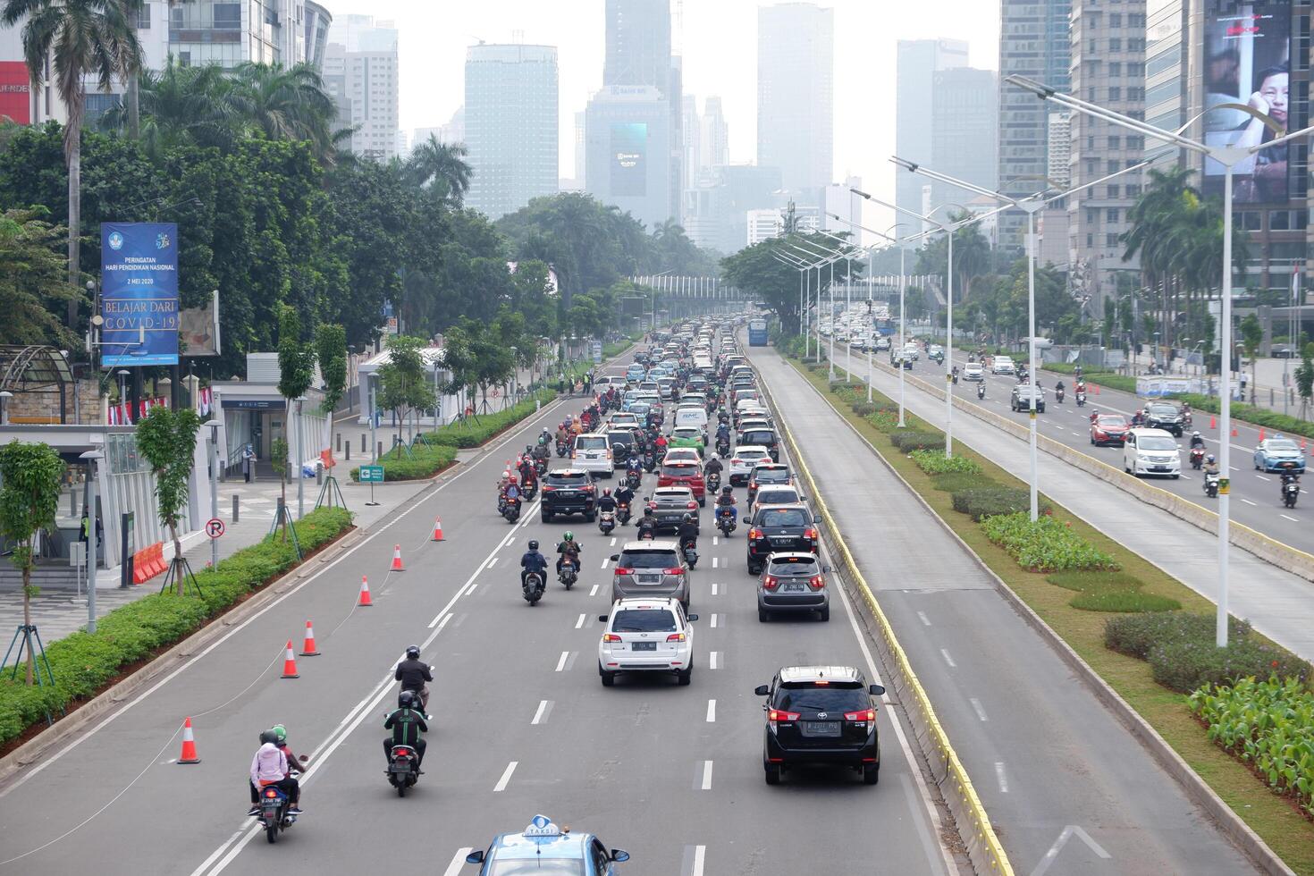 Busy morning in Jakarta, traffic congestion, rush vehicle on weekdays and skyscrapers on main road of business and office centers Jakarta, Indonesia - July 3, 2020 photo