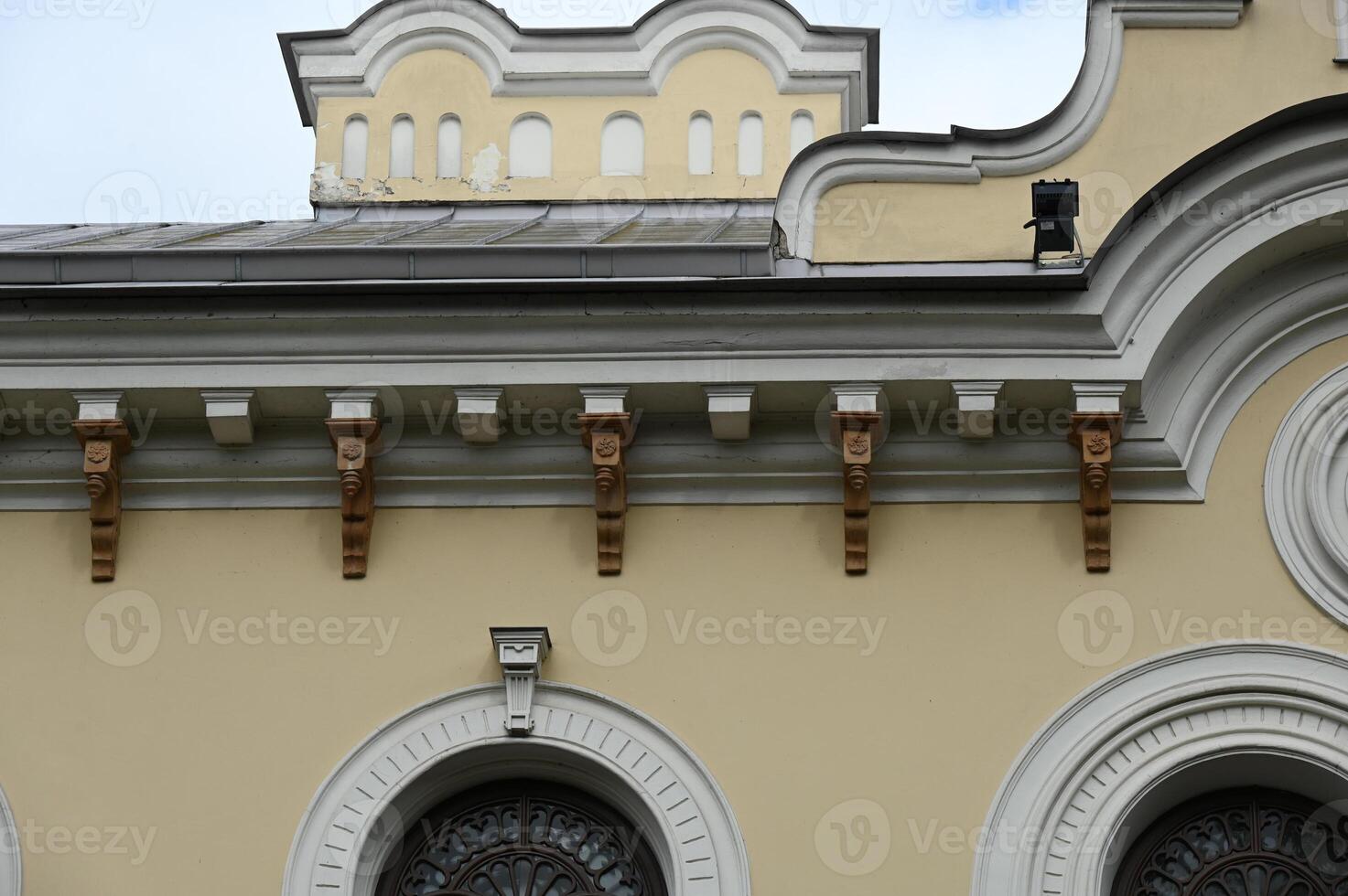 the top of a building with arched windows and a clock photo