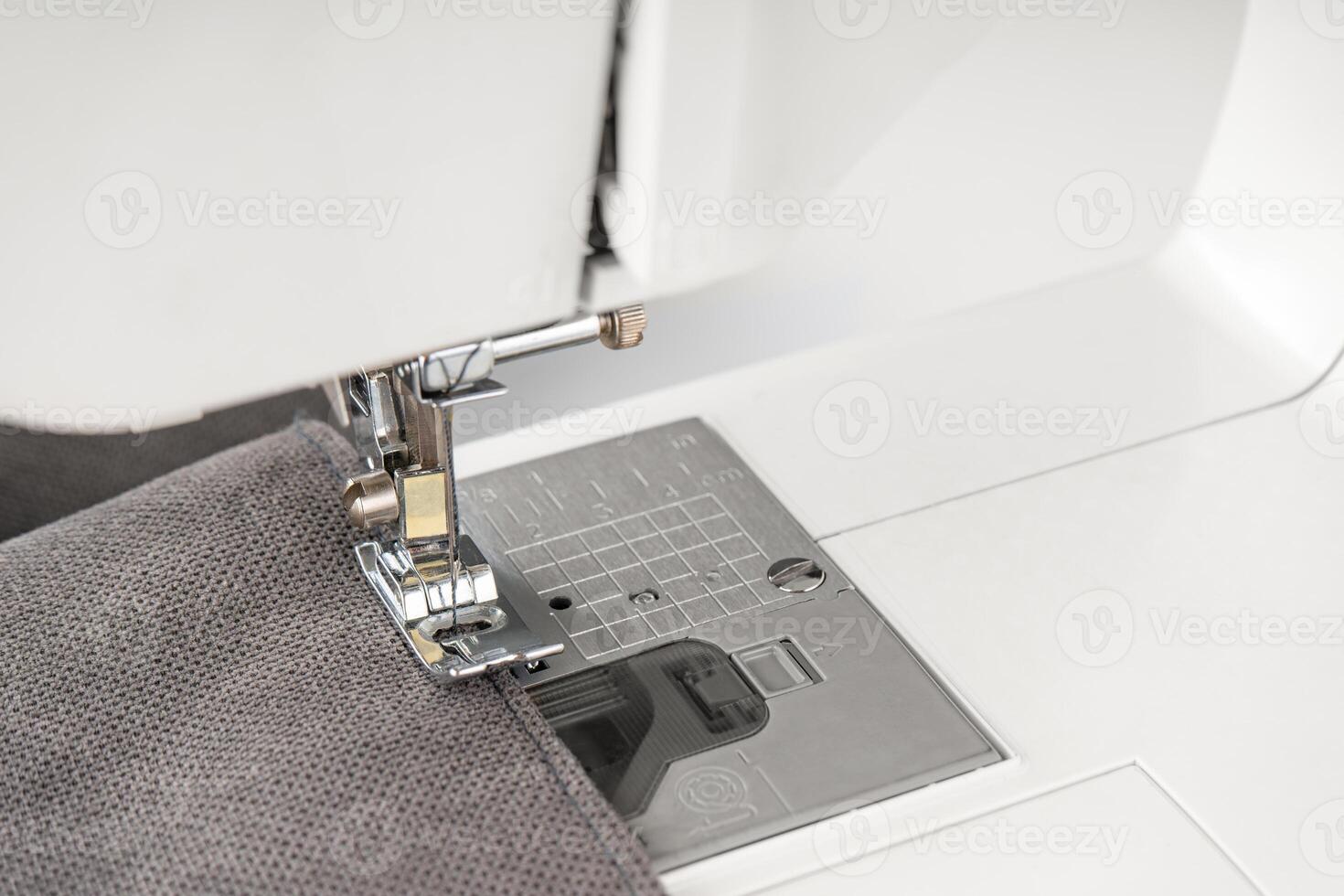Modern sewing machine with gray fabric photo