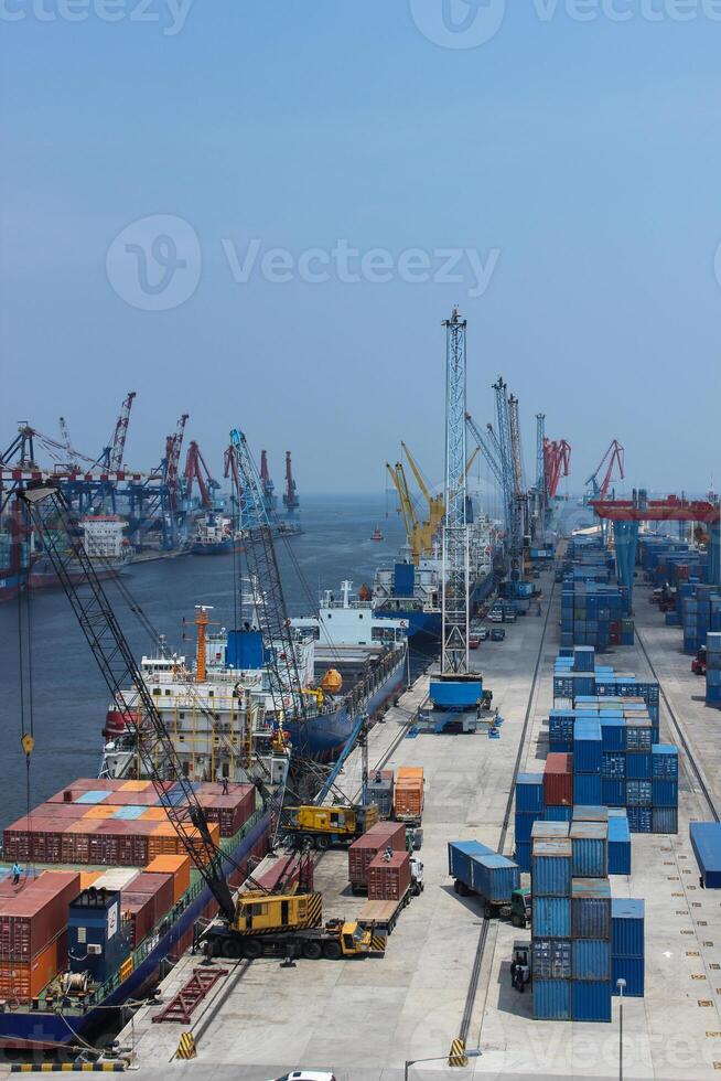 High angle view of commercial port with cranes and shipping containers, cranes move the shipping container to unload from cargo vessels photo