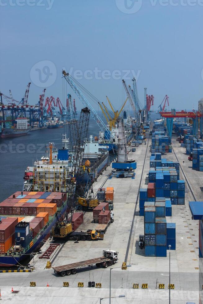 High angle view of business commercial port with cranes and logistics containers, cranes move the shipping container to unload logistics from cargo vessels photo
