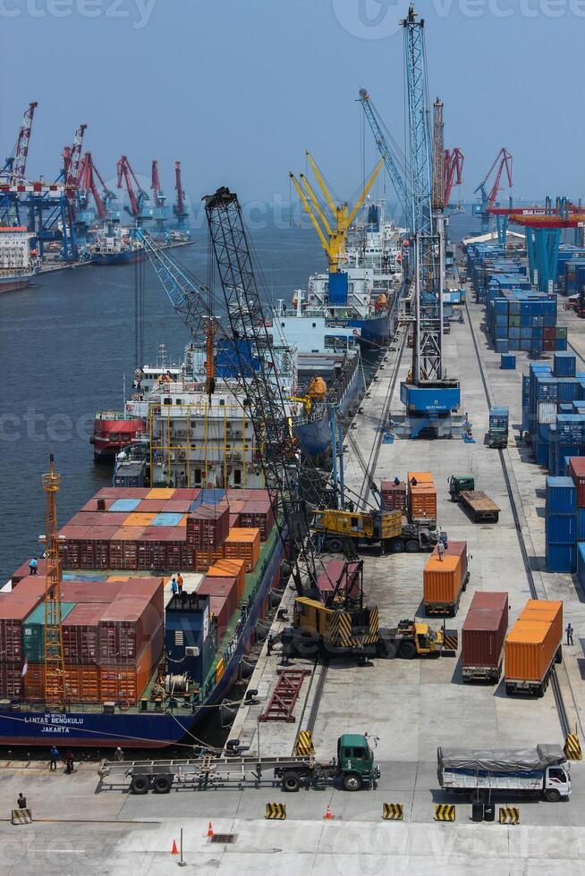 High angle view of business commercial port with cranes and logistics containers, cranes move the shipping container to unload logistics from cargo vessels photo