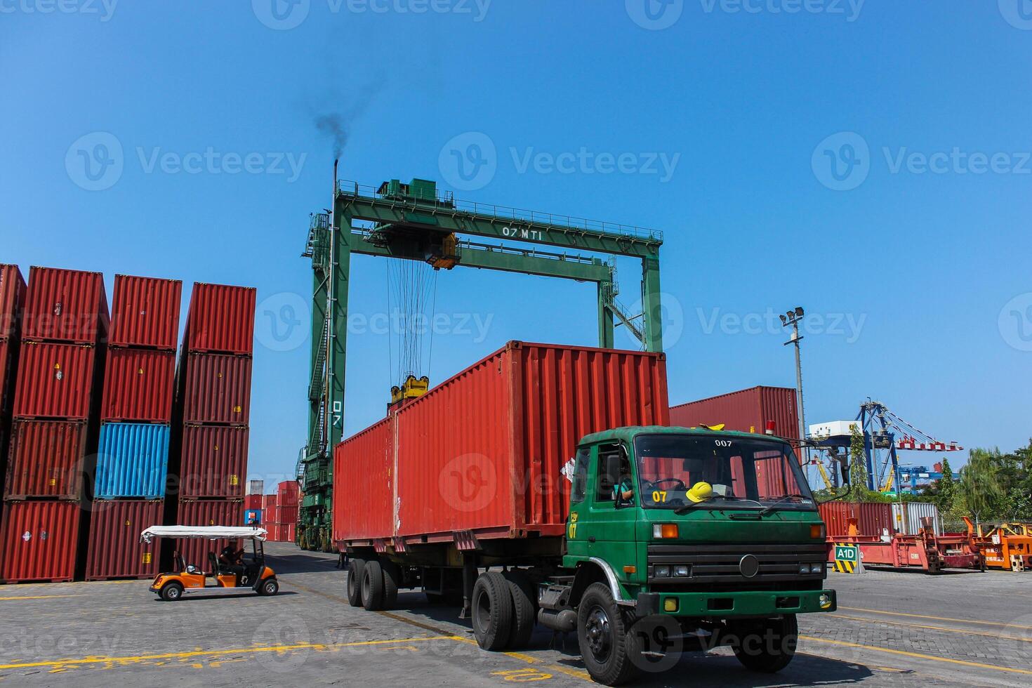 Loading and unloading shipping containers in an export import and commercial port with industrial crane and truck as transportation mode photo
