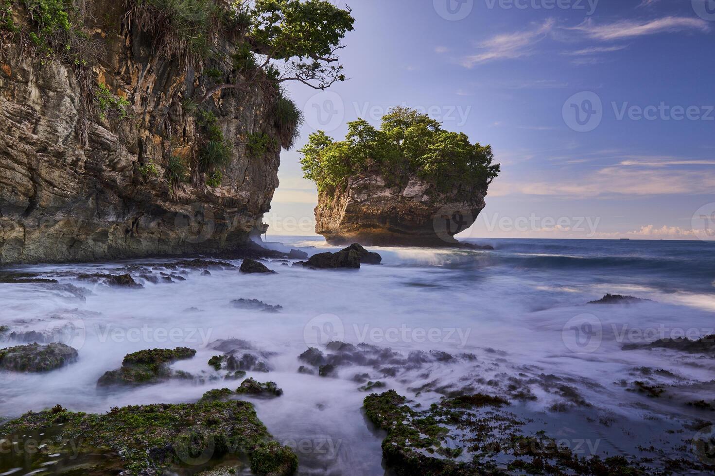 Beautiful scenery of rocky beach with cliffs and large waves in long exposure photography in Sawarna, Banten, Indonesia photo