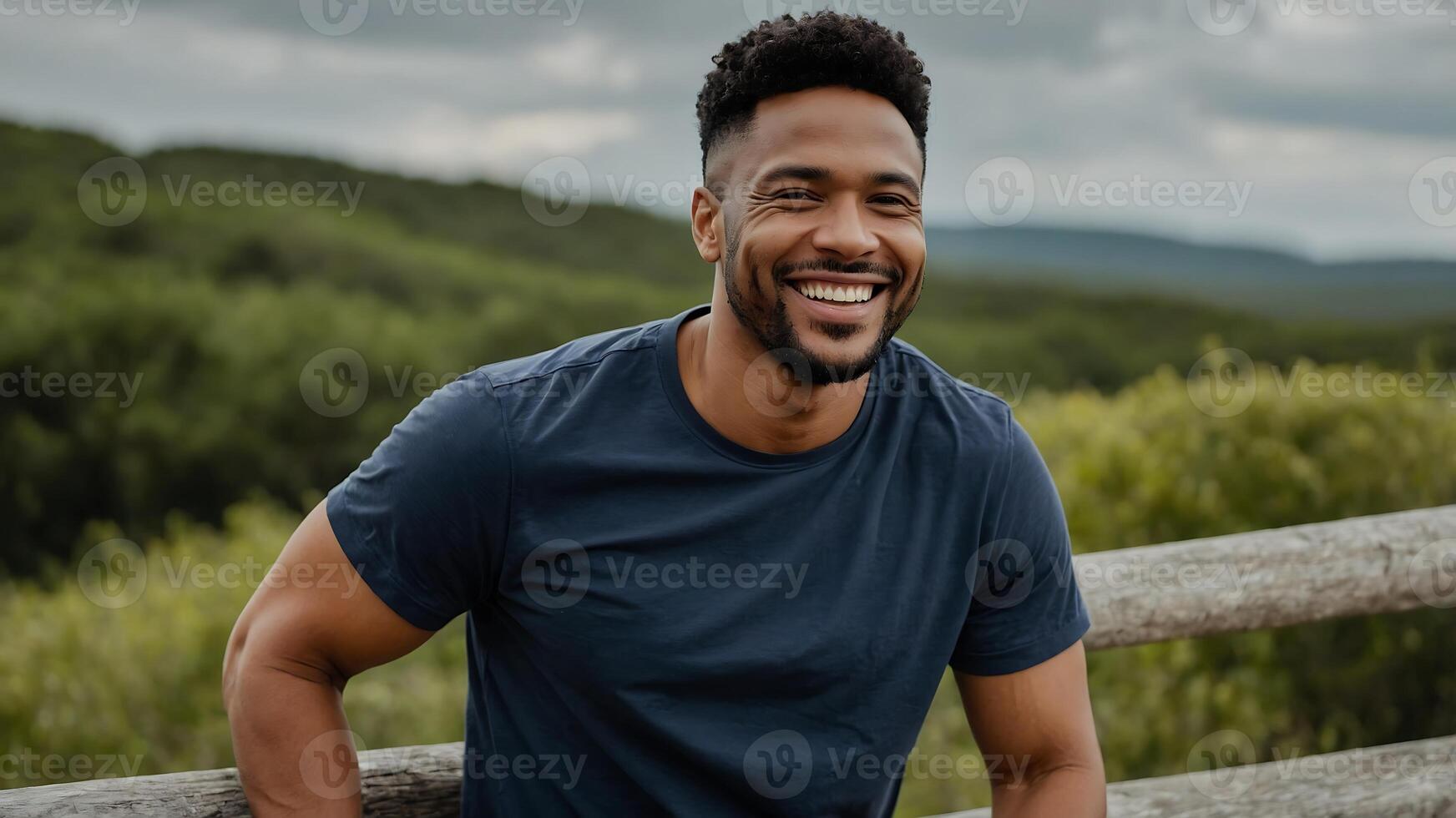 A man smiling while sitting on a wooden fence photo