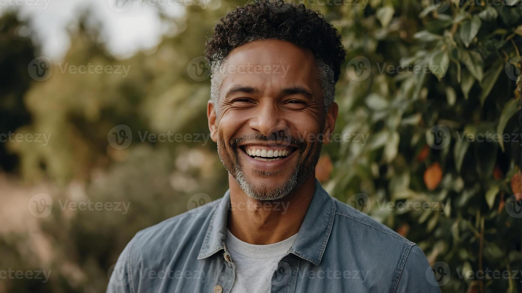 A smiling man in front of trees photo