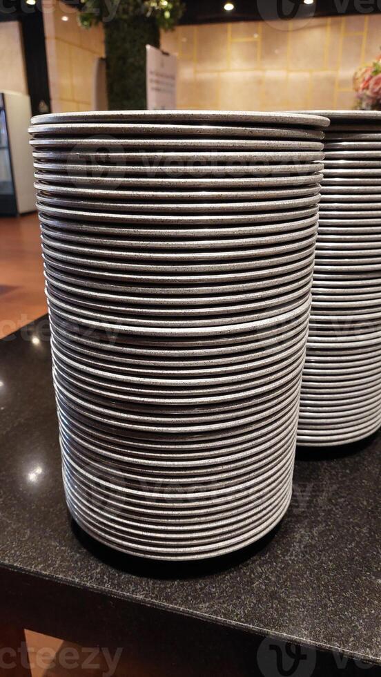 White ceramic plate on restaurant, close up. Stacked varied dishes on dark background photo