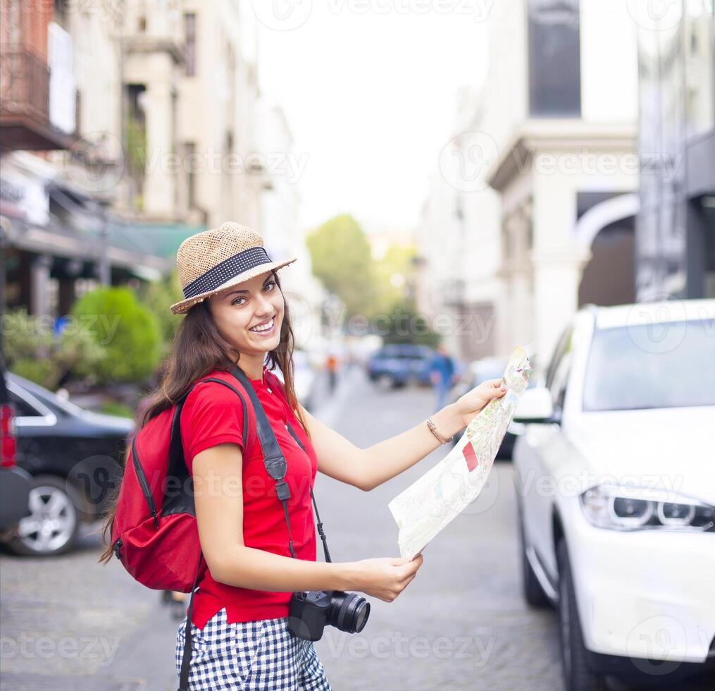 Portrait of a beautiful female tourist searching a place on the map photo