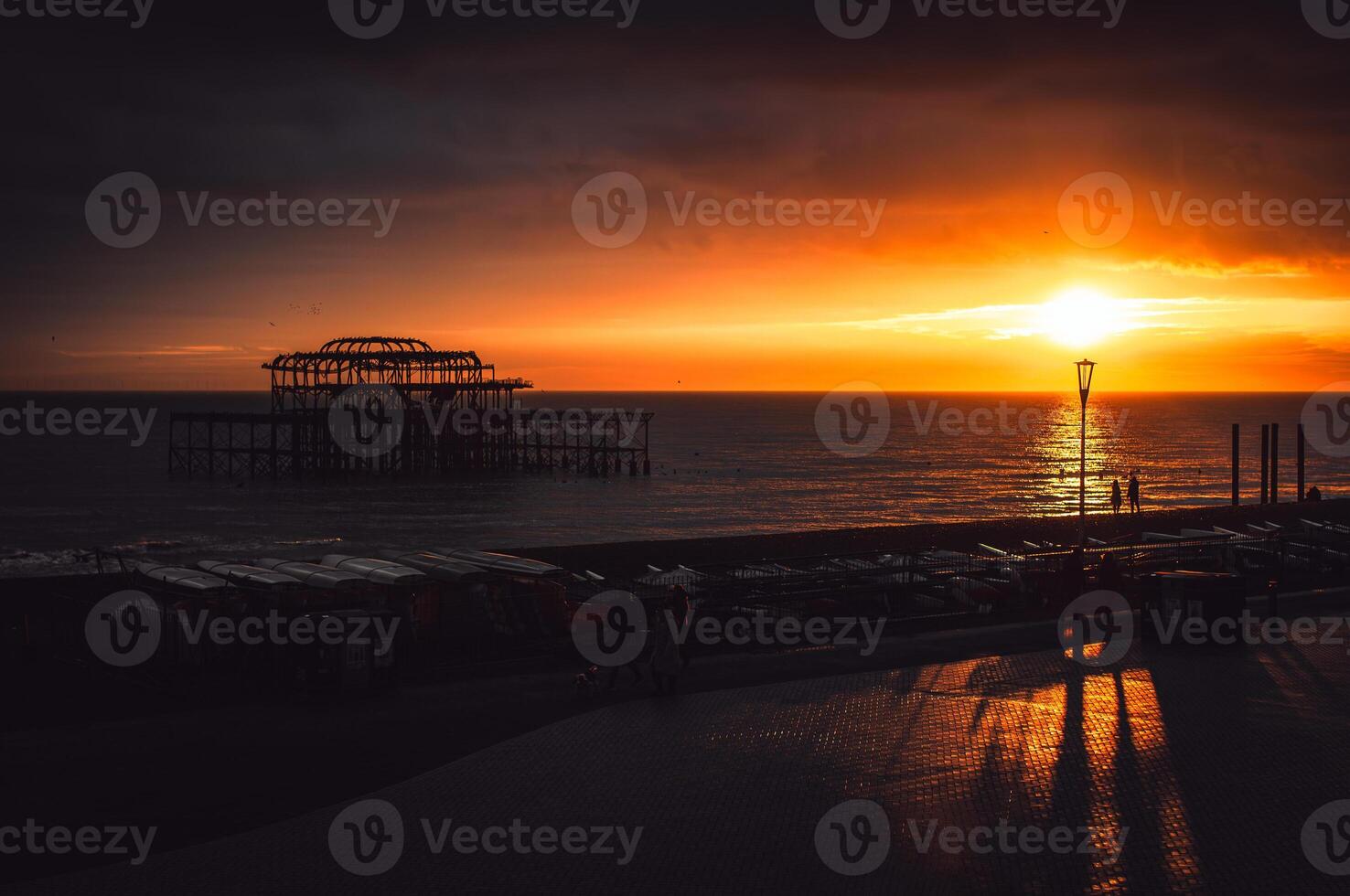 Sunset and Pier, dark, heavy sky in Brighton, East Sussex, UK photo