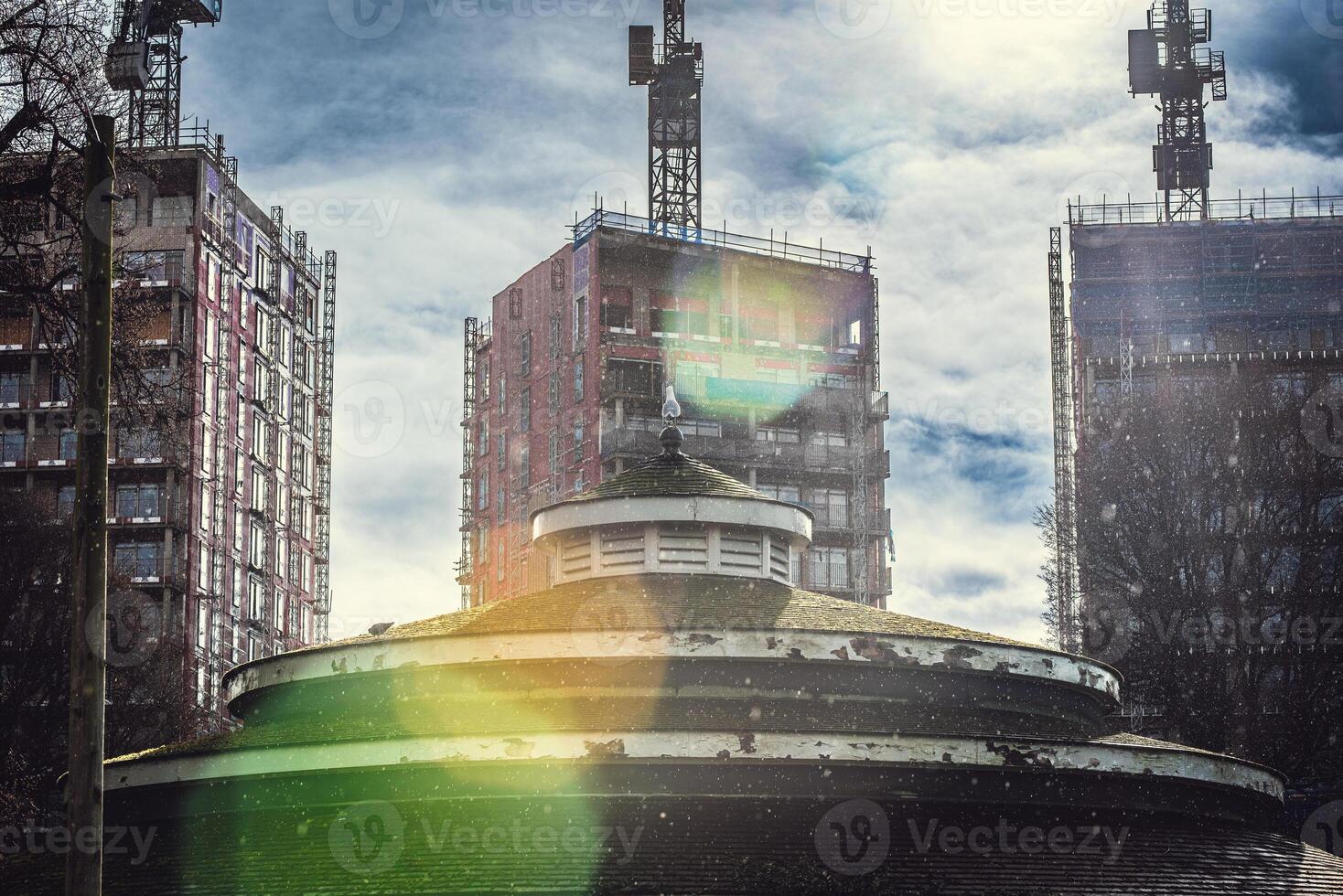 Building side in with crane in a background on a rainy and day with sun flare, Brighton, East Sussex, UK photo