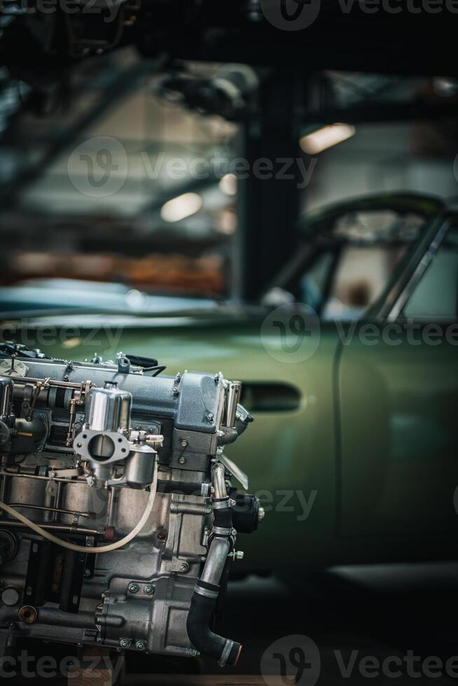 Newly restored engine for a classic car in a background stored in a vintage car restauration garage. photo