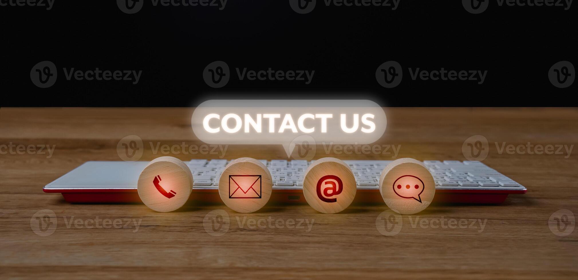 Contact us concept with red and white icons on wooden table photo