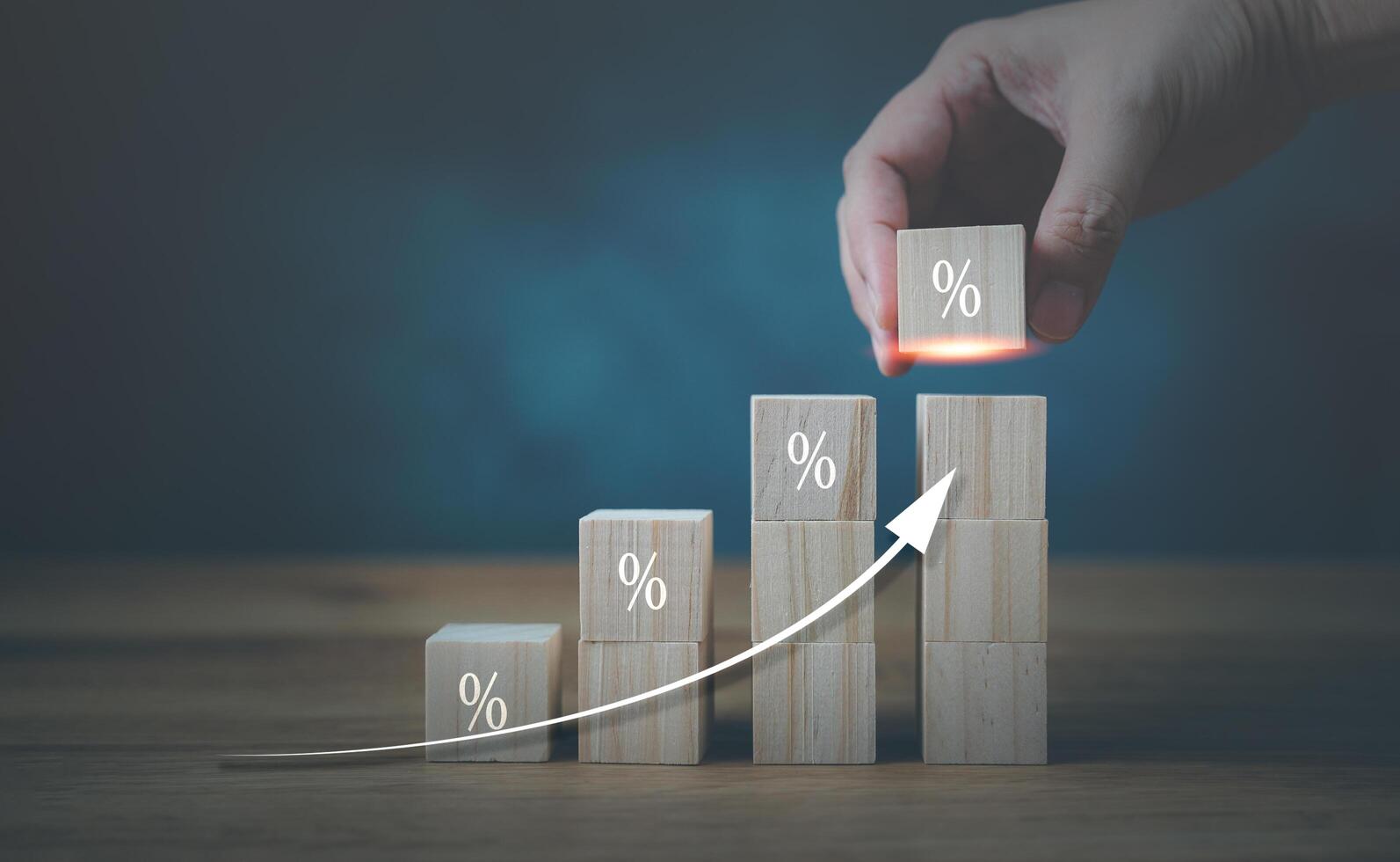 A hand is placing wooden blocks on a wooden table with a graph photo