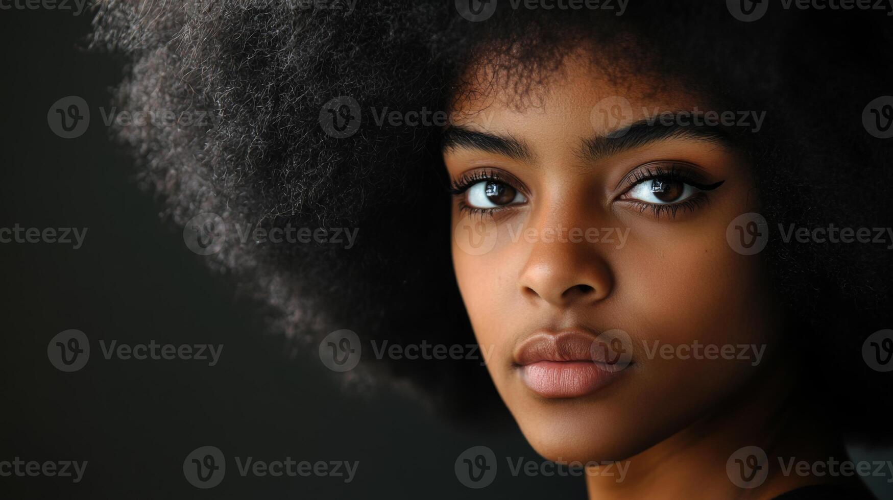 A portrait of a Black woman with an afro, looking directly into the camera, exuding self-assurance and pride photo