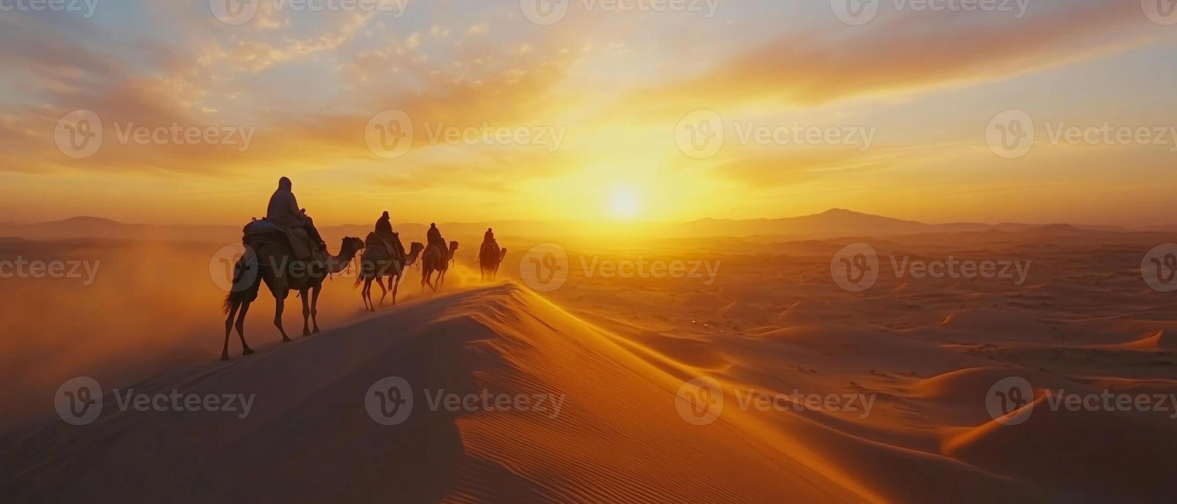 A camel caravan crossing vast desert dunes at dusk, warm light on the sand photo