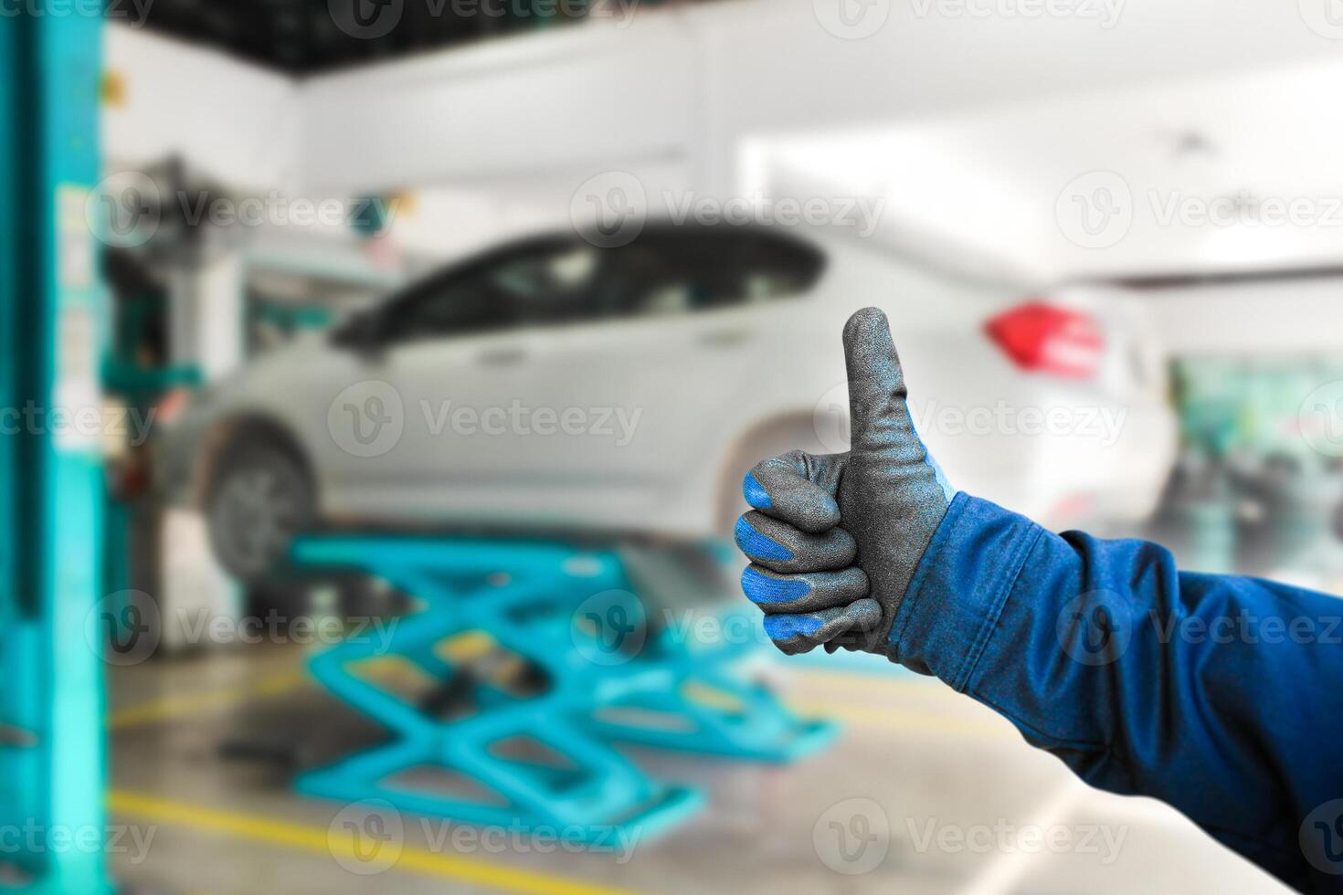 Thumb up for car repair work , The auto mechanic gives a thumb up to show confidence in a good job , Car maintenance service concept photo