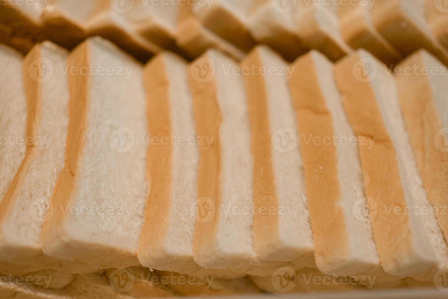 Bread slices are arranged in rows on trays in the hotel restaurant for breakfast. photo