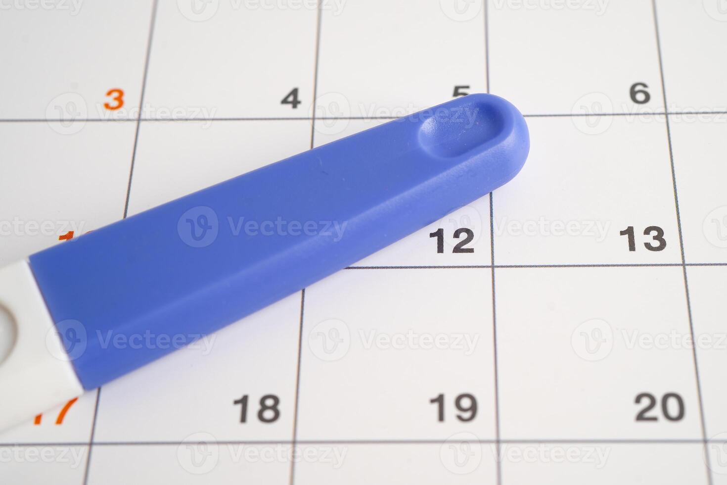 Pregnancy test and birth control pills on calendar, contraception health and medicine. photo