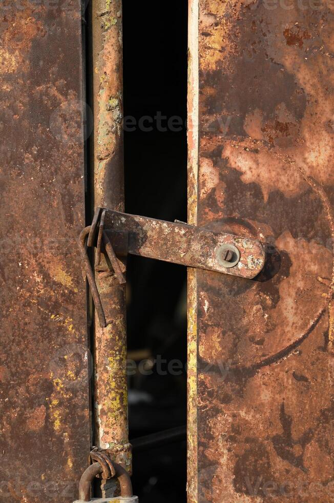 a rusty door with a padlock on it photo