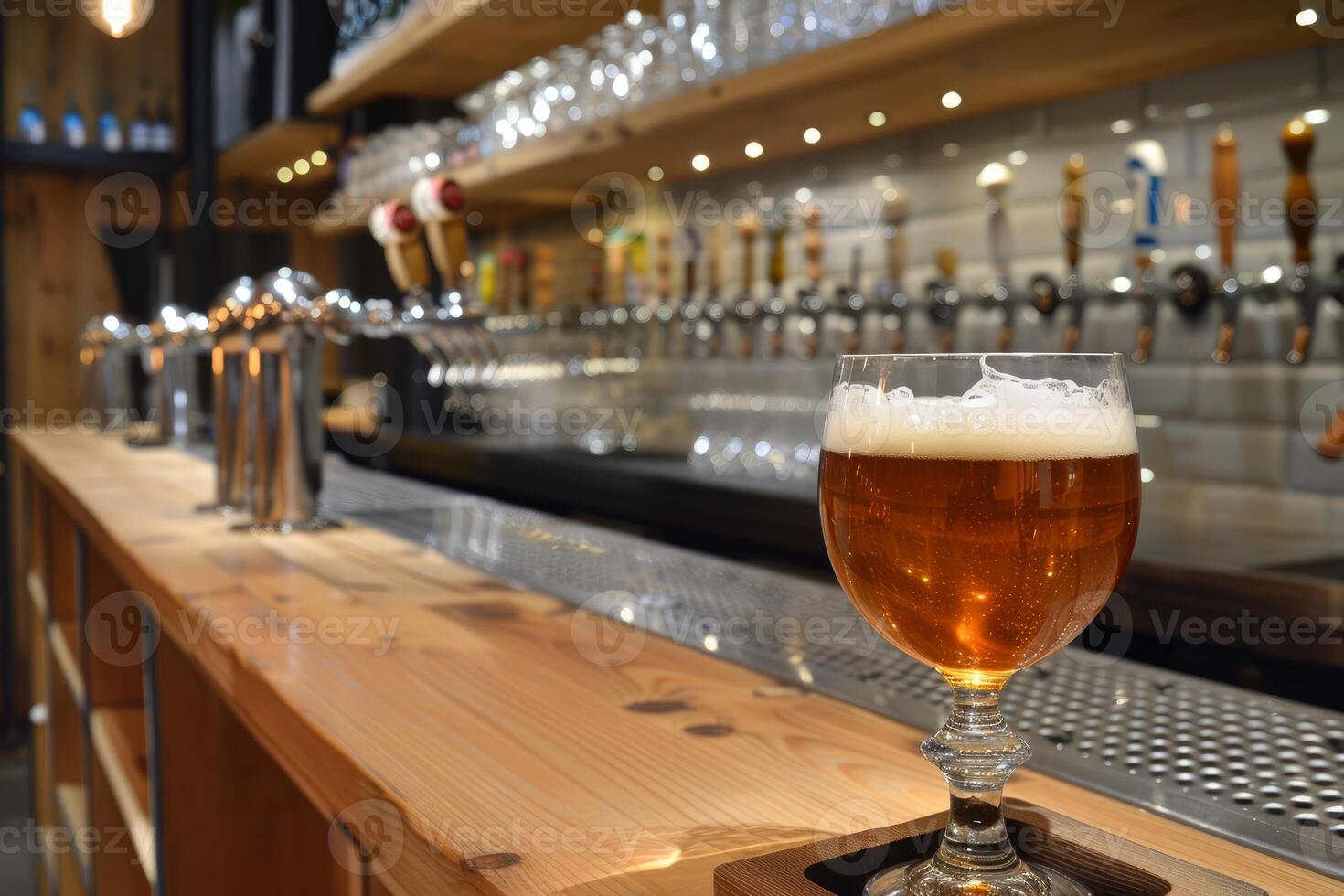 Glass of amber beer standing on counter in busy bar photo