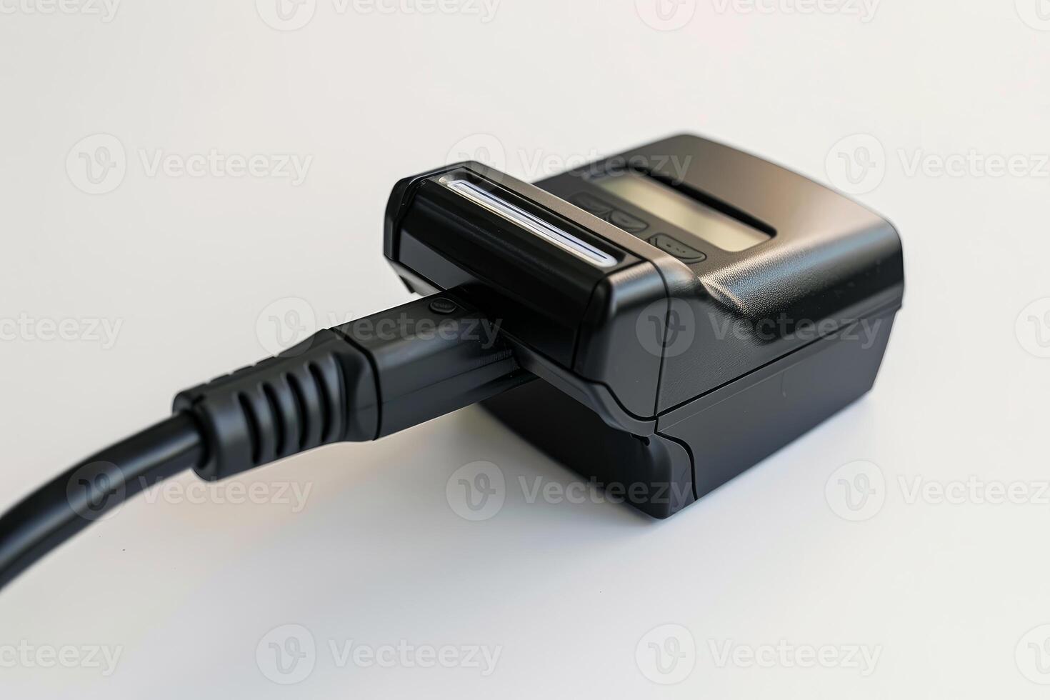 Electronic device being charged with power cord on white background photo
