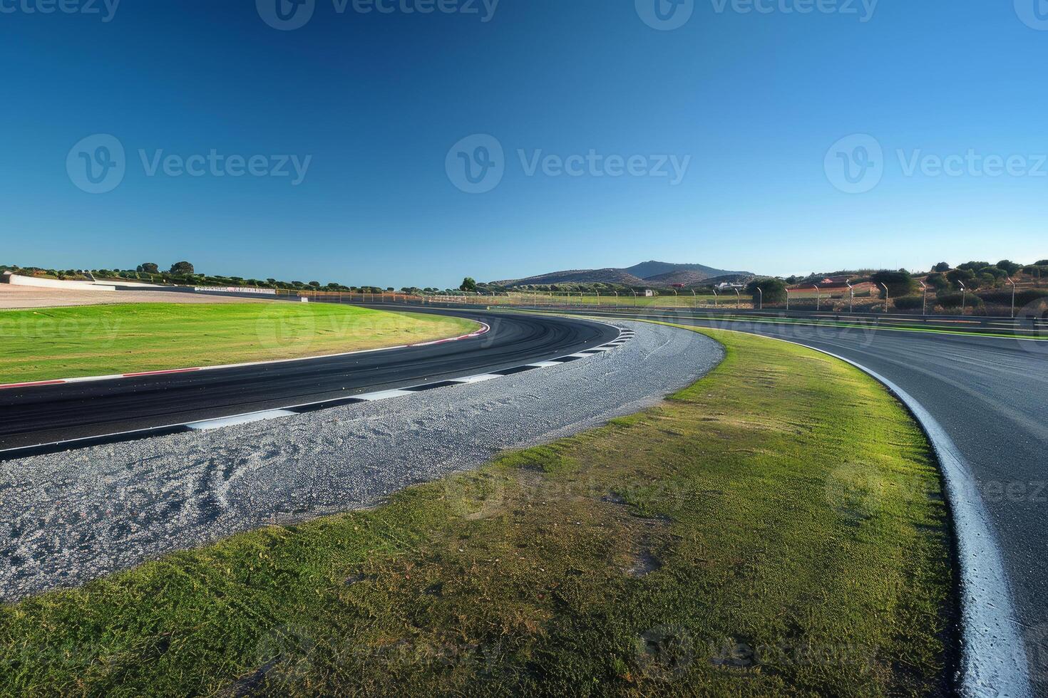 Empty race track curve winding through green landscape on sunny day photo