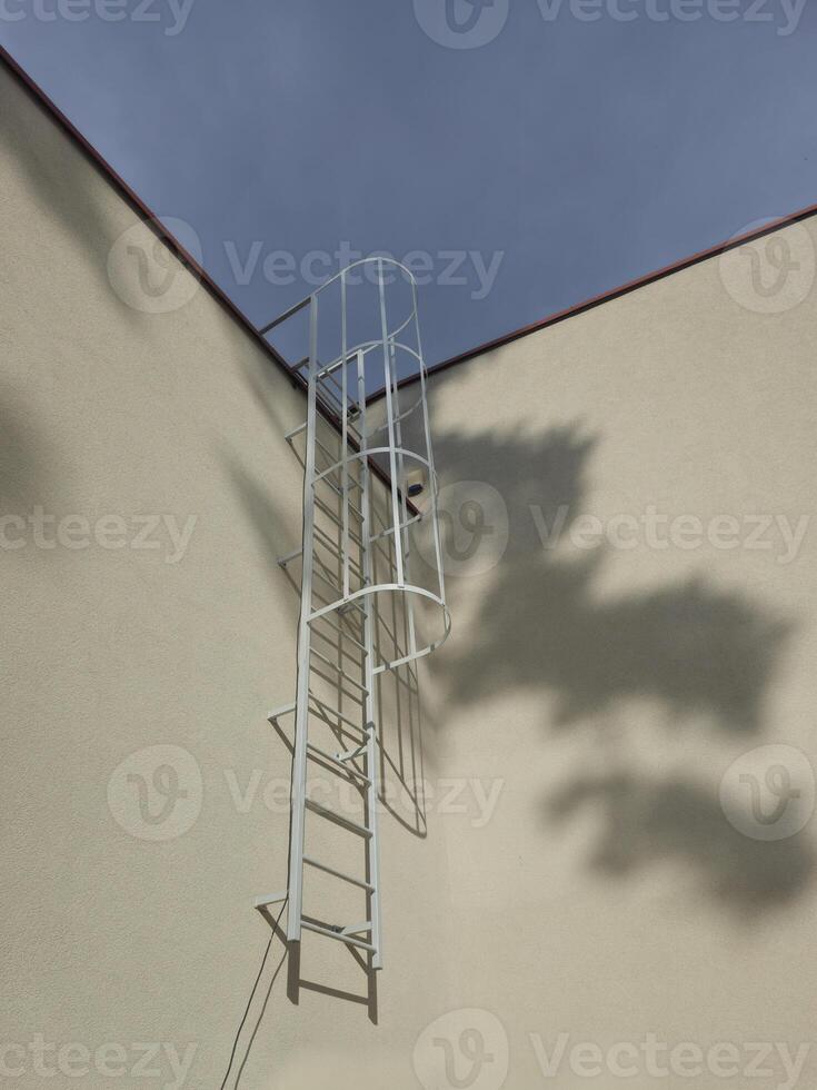 a ladder on the side of a building against a sky photo