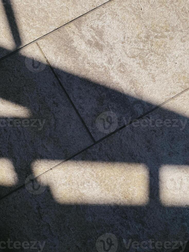 Shadows on textured stone surface, abstract geometric pattern. Light and shadow, contrast, composition. Minimalist, everyday materials. Ideal for backgrounds or textures photo