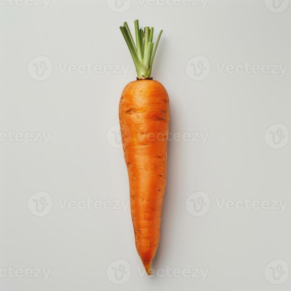 a single carrot on a white surface with a green stalk photo