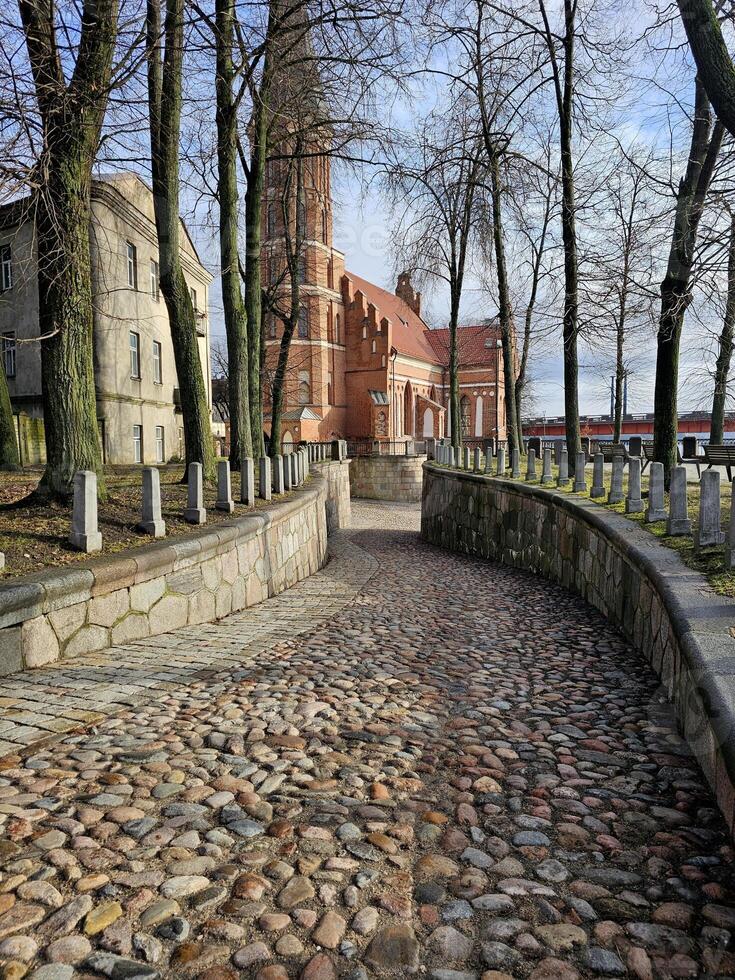 a cobblestone road with a church in the background photo