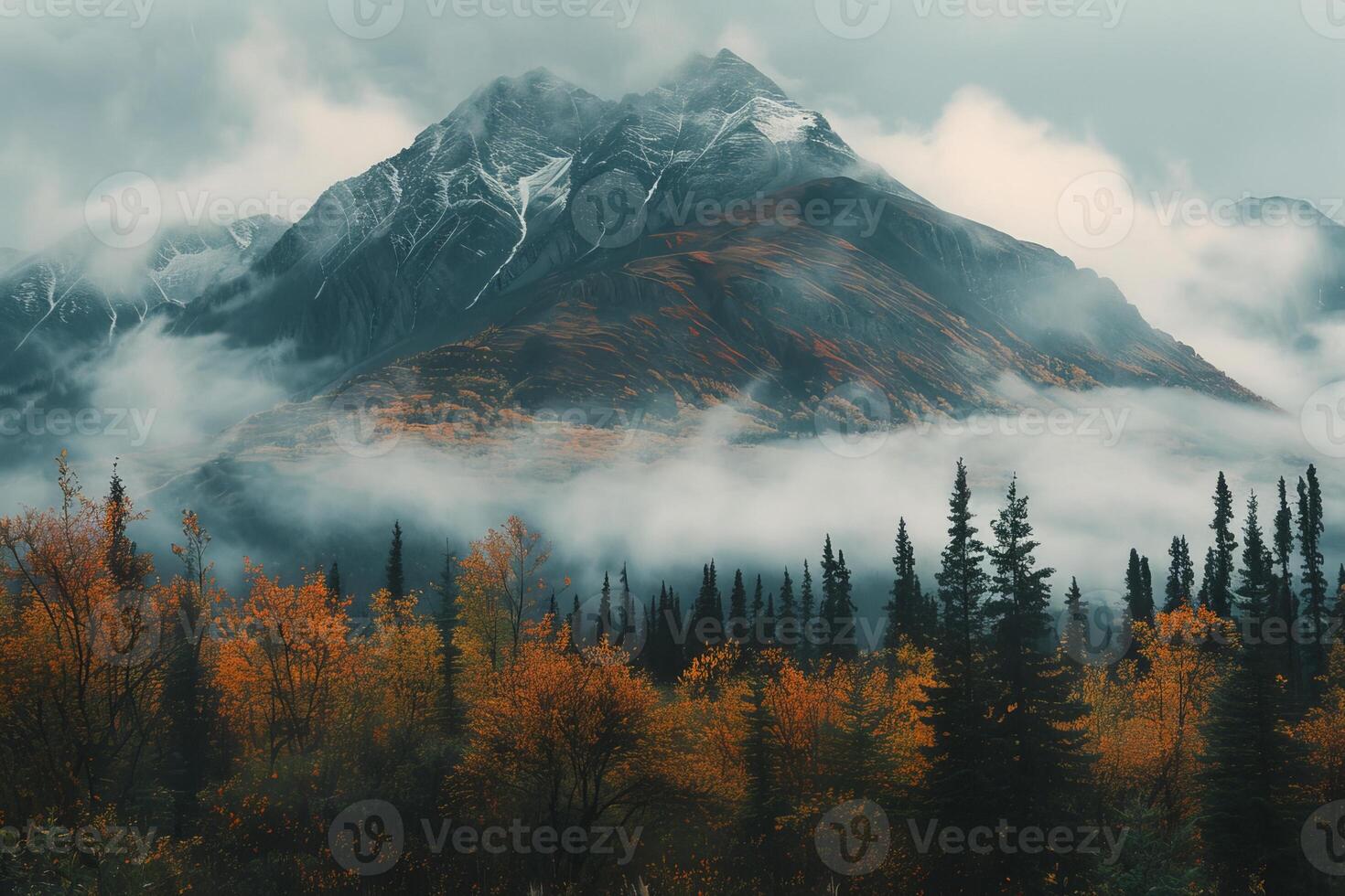 Fog rolling in on mountain peak over autumn forest photo
