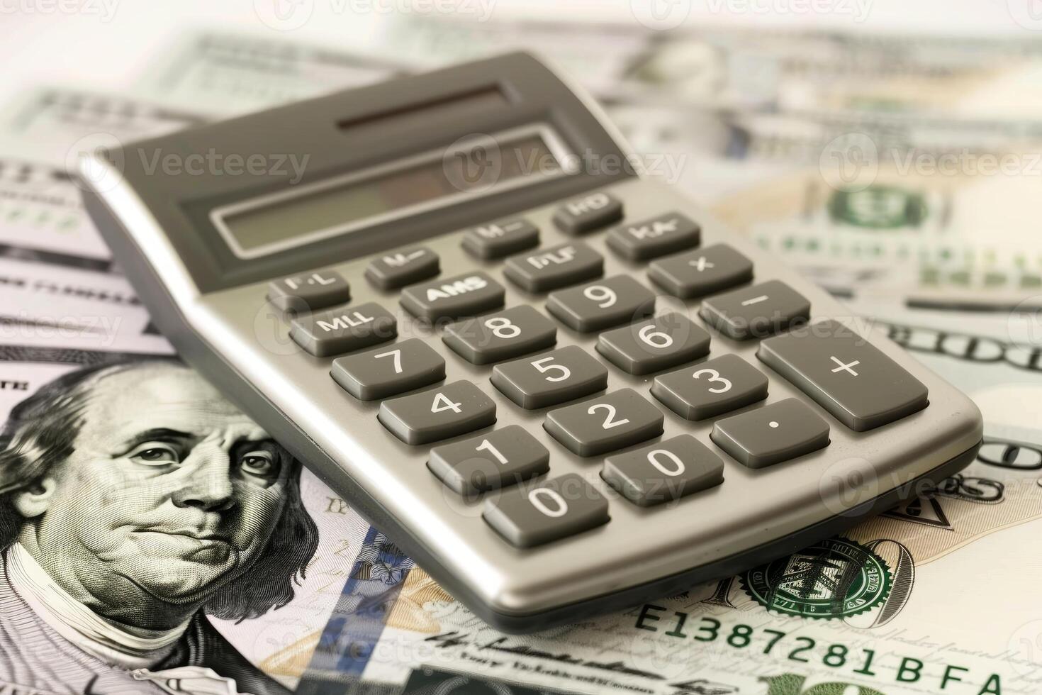 Calculator lying on one hundred dollar bills calculating savings photo