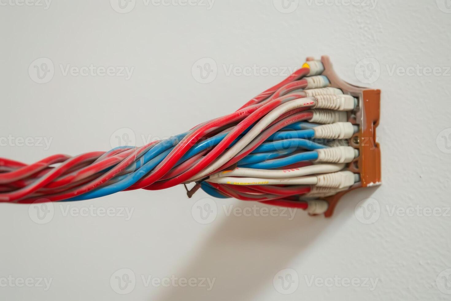 Electrician installing many electrical cables into power socket on wall photo