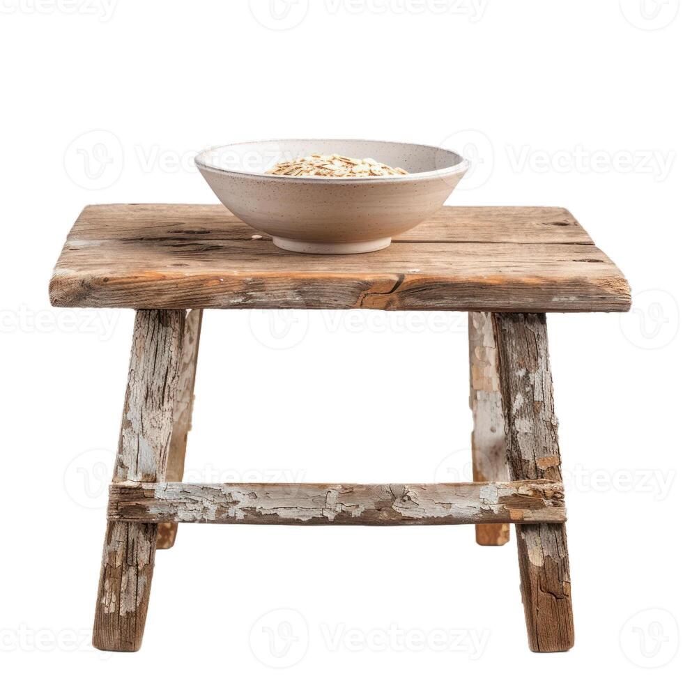 Bowl filled with rolled oats resting on rustic wooden stool photo