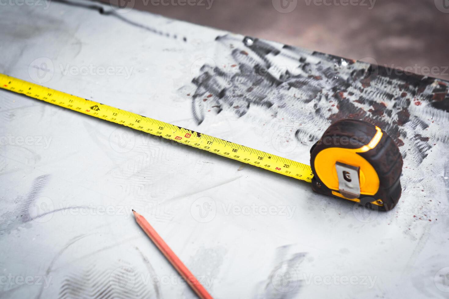 Yellow measuring tape or tape measure on a metal desk for measuring the size of materials , Mechanic tools concept photo