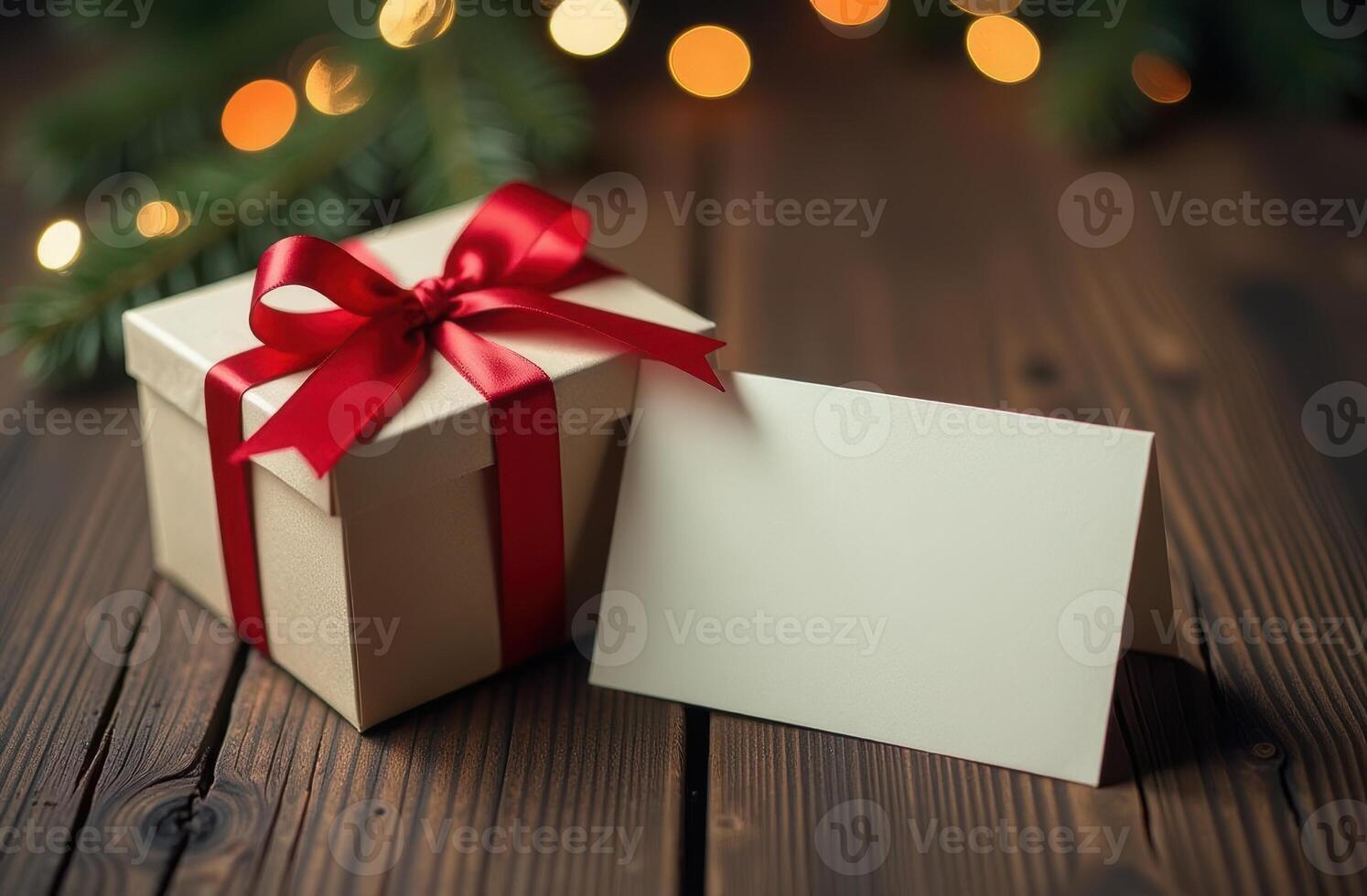 Gift Box with Red Ribbon and Blank Card on Wooden Table, Festive Christmas Lights in Background. Perfect for Holiday Themes photo