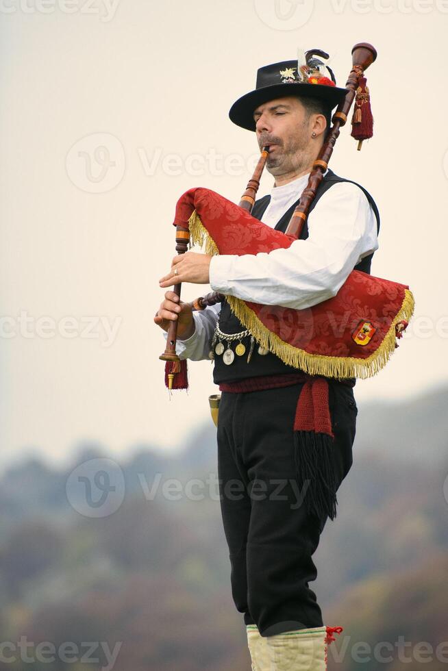 Musician plays bagpipes in the mountains photo
