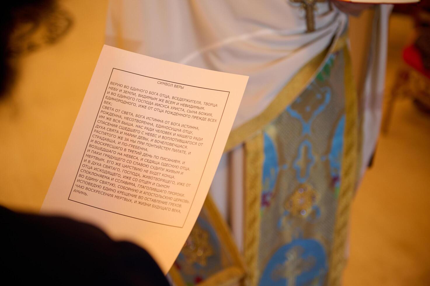 Person holding a religious text during a ceremonial event photo
