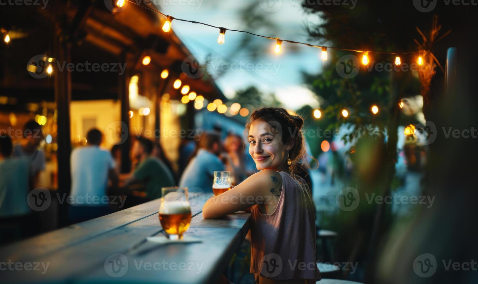 Young woman at a local craft brewery at twilight, enjoying beer drinks photo