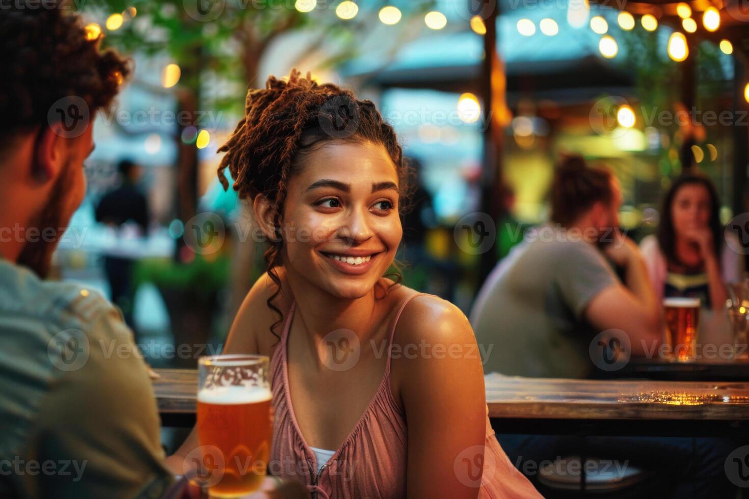 Young woman at a local craft brewery's patio area at twilight, enjoying drinks and the sense of community photo