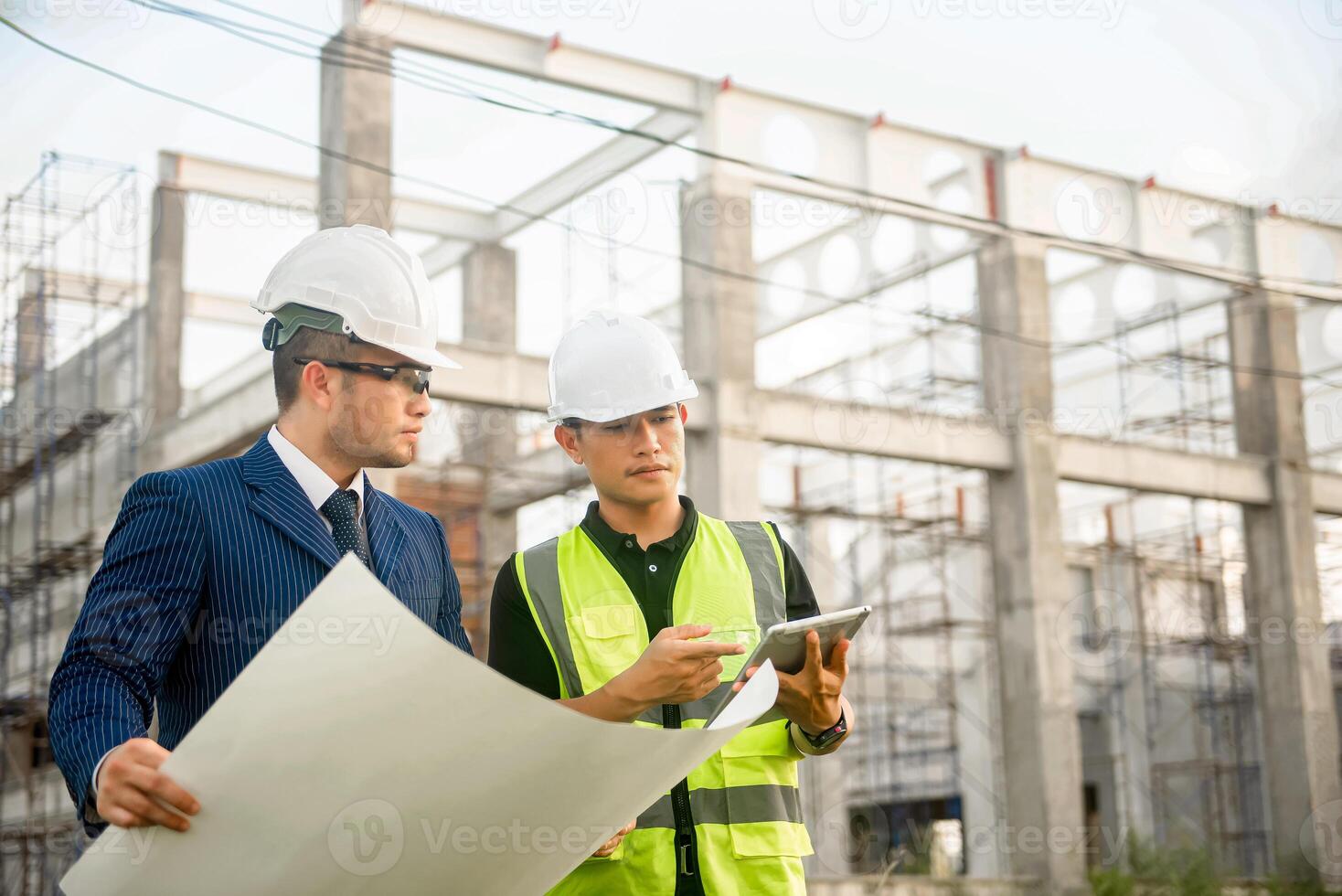 Engineer and architect monitor the progress of building construction plan and verify their accuracy. photo