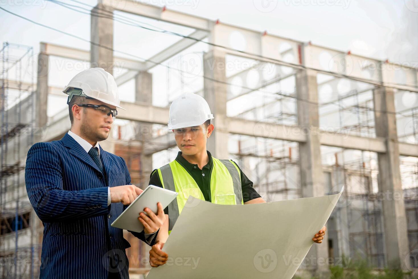Engineer and architect monitor the progress of building construction plan and verify their accuracy. photo