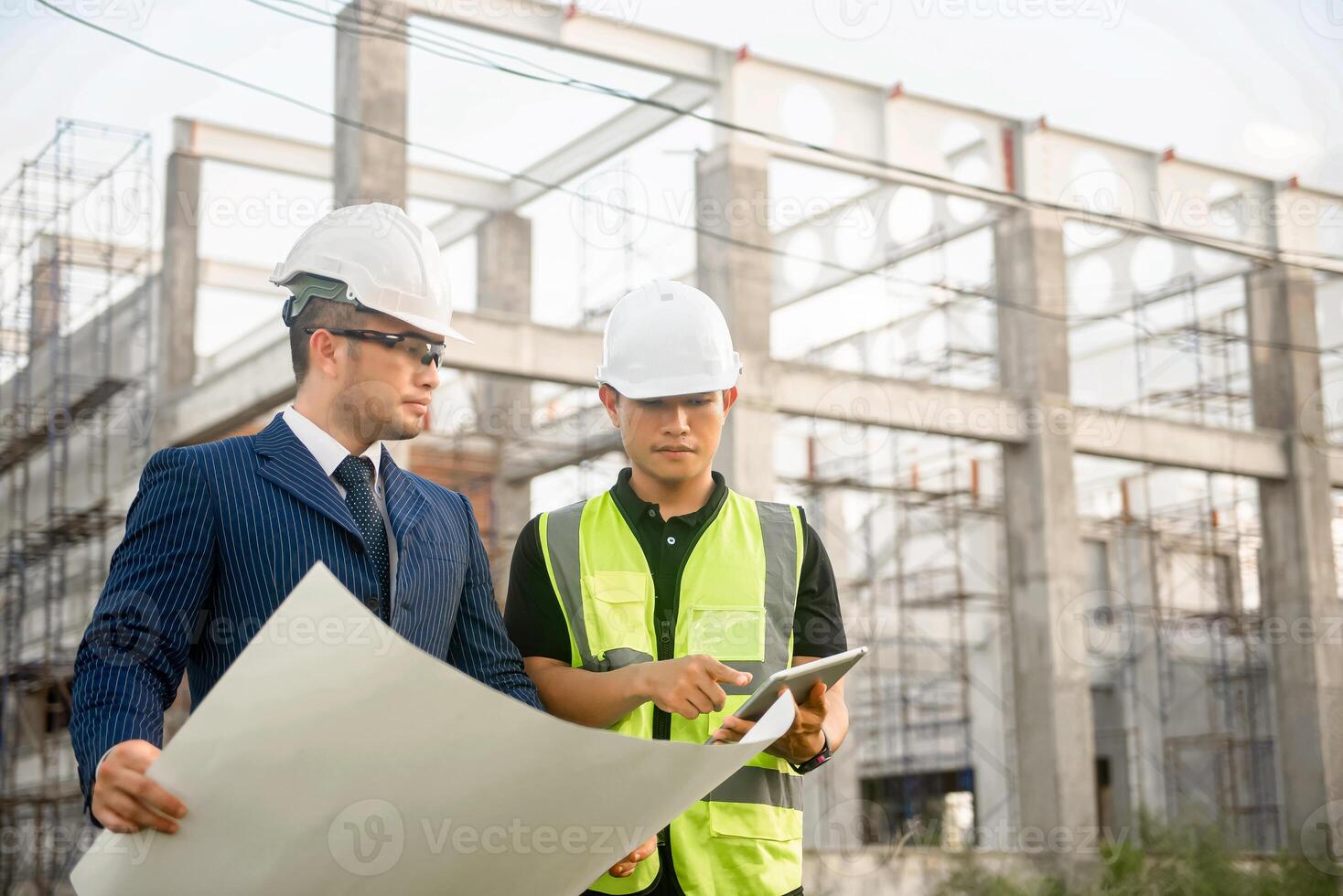 Engineer and architect monitor the progress of building construction plan and verify their accuracy. photo