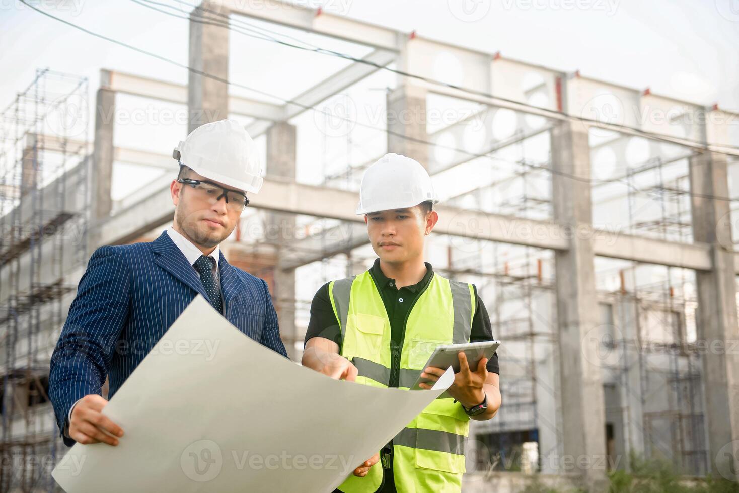 Engineer and architect monitor the progress of building construction plan and verify their accuracy. photo