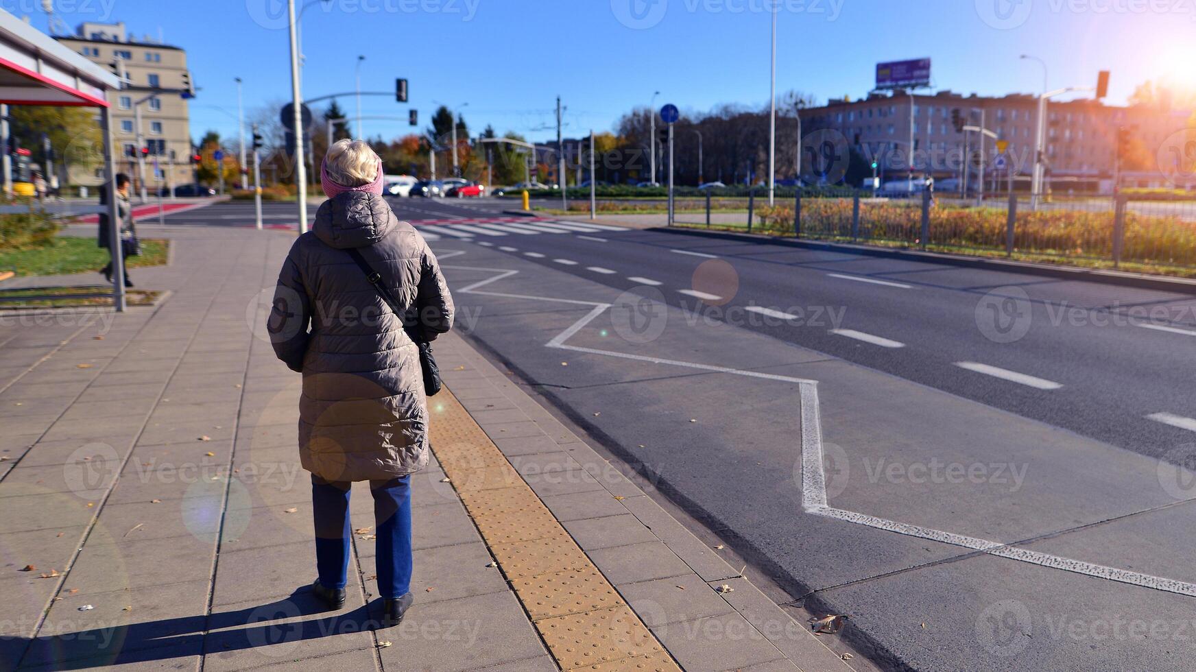Tram stop where elderly old woman are seen waiting. The concept of a senior on the street. photo