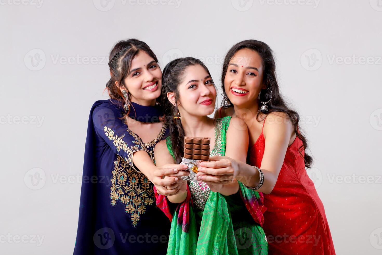 Gorgeous Three Besties Friends Showing Chocolate Bar at Camera photo