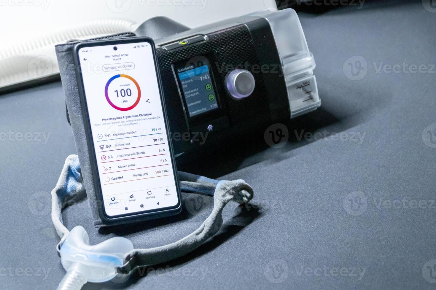CPAP machine with nose CPAP mask and stats on smartphone display with digital app for treatment stats and medical reports or health reports and digital assistant for therapy analysis therapy reports photo