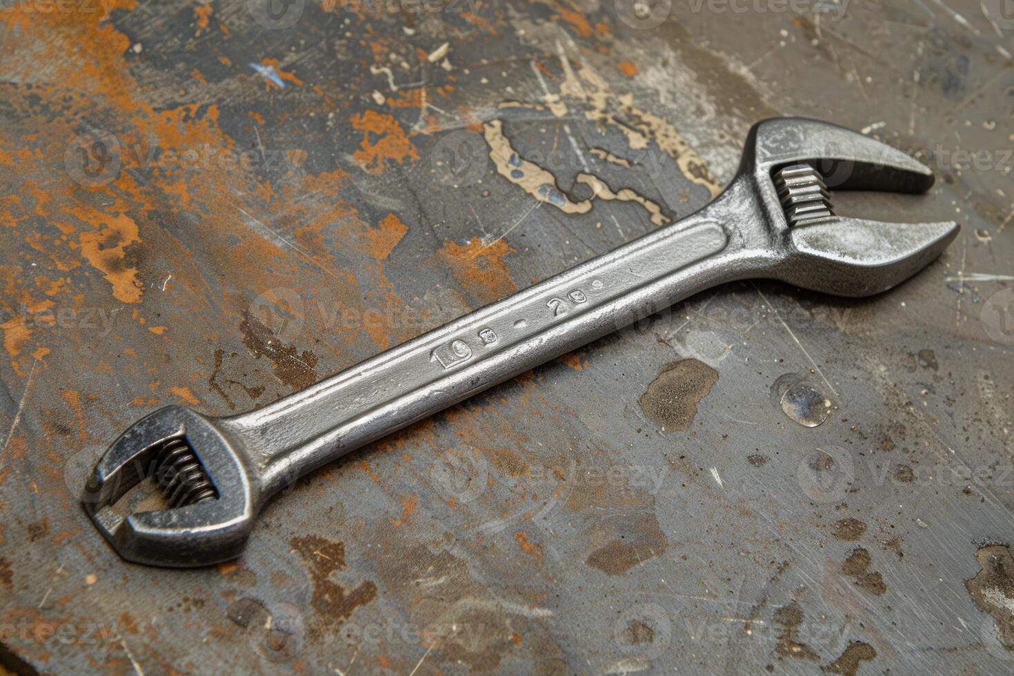 Adjustable wrench lying on metal surface in workshop photo