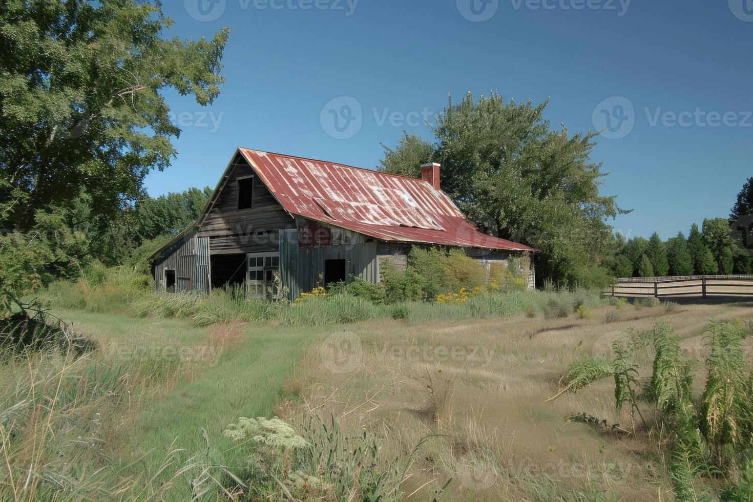 Old weathered barn sitting in a field surrounded by grass and trees photo